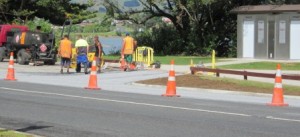 Workers finish off tar sealing the road verge outside the new museum on Monday