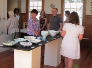 Visitors study the clay art