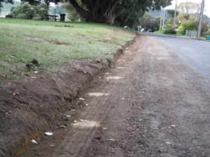 Photo in northern area of Cliff St shows the 'shoulder' being cut back apparently ready to be resealed.  The pale circles show where WDC installed then removed bollards in this area just a few years ago.