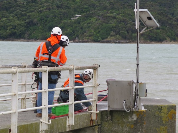 Workers install the permenant safety barrier on the dolphin pier