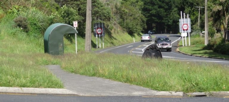 Messy grass verge where SH 23 stops and Main Road begins.