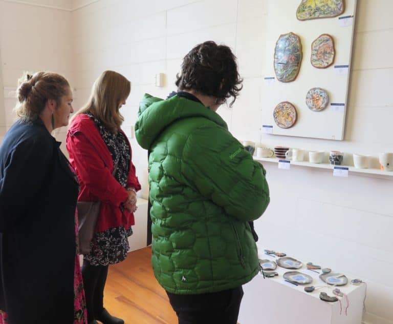 Exhibition visitors study some of the works