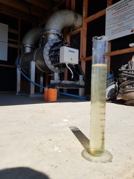 Photo inside the pump and UV building of a measuring cylinder with a sample  of Raglan purified waste water